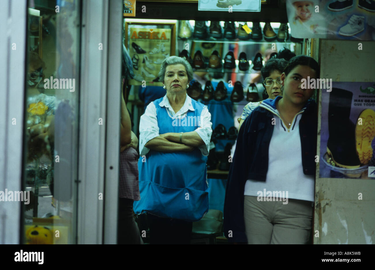 Müde und gelangweilt Arbeiter schauen aus einem Geschäft in Panama-Stadt im Laufe des Abends. Stockfoto