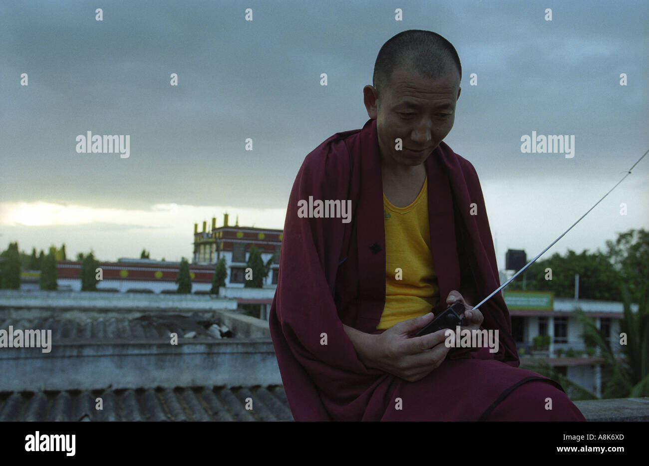 Ein tibetischer Mönch hört Nachrichten aus der Außenwelt über Kurzwelle. Stockfoto