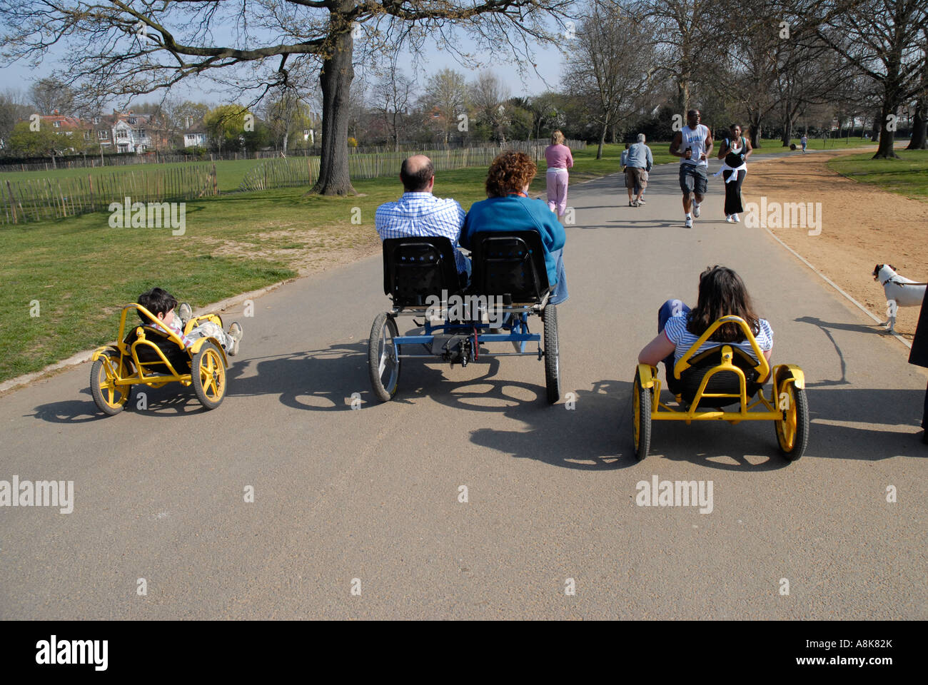 Familie in Dulwich Park auf verschiedene Arten von recumbent Fahrräder und Karren. Stockfoto