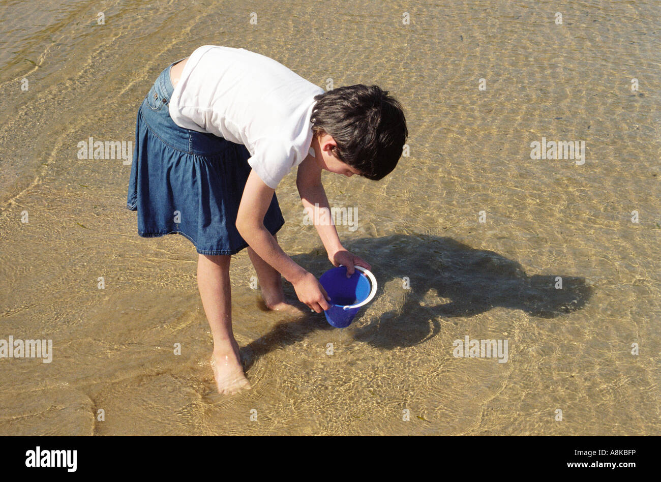 Ein junges Mädchen spielen am Strand mit einem Eimer Stockfoto