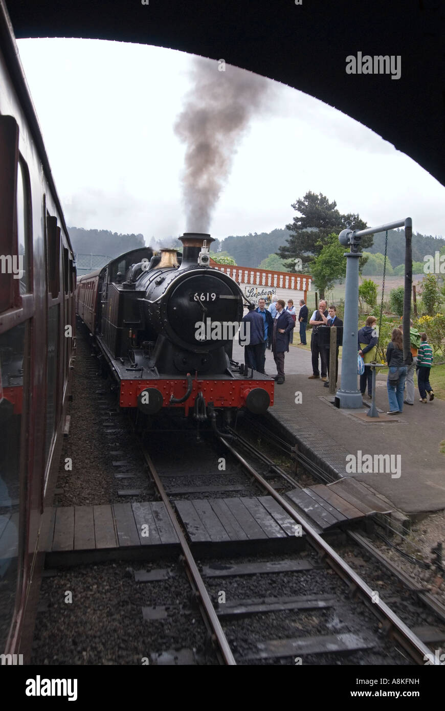 Vertikale Weitwinkel von einer Dampfmaschine und Kutschen an Weybourne Station auf der historischen Mohn-Linie gestoppt. Stockfoto