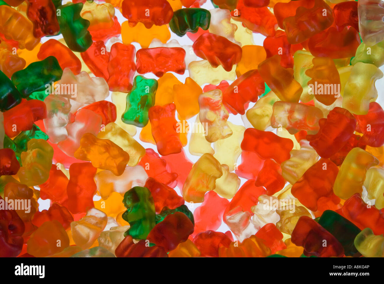 Horizontale Nahaufnahme von vielen bunten Gummibärchen oder Teddybär Gelee-Süßwaren auf weißem Hintergrund Stockfoto