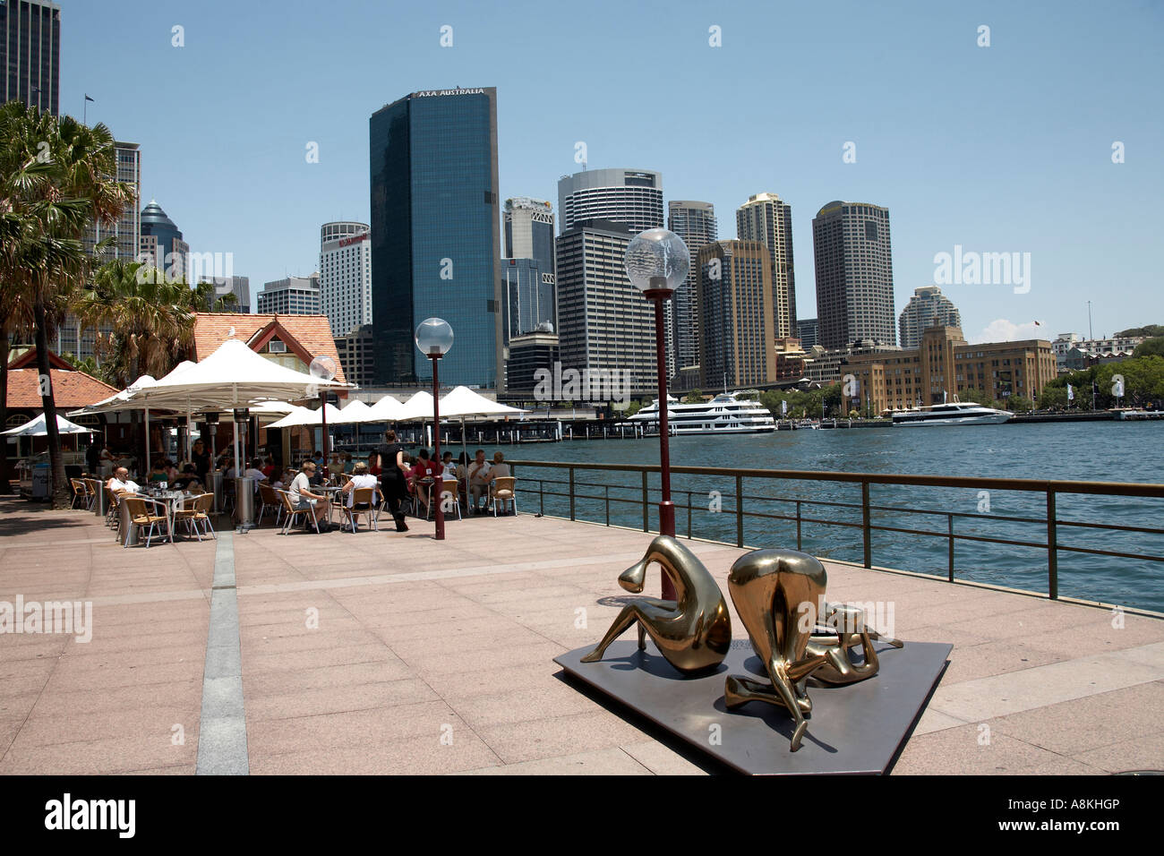 Menschen Essen und trinken außerhalb am Hafen Café Opera Quay mit Skulptur und Bürogebäuden in Sydney New South Wales. Stockfoto