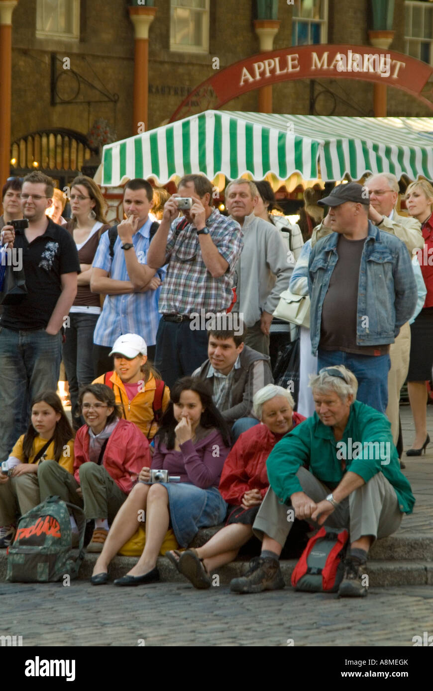 Vertikale Nahaufnahme von den Massen durch ein Straßenkünstler auf der Piazza in Covent Garden an einem sonnigen Abend unterhalten. Stockfoto