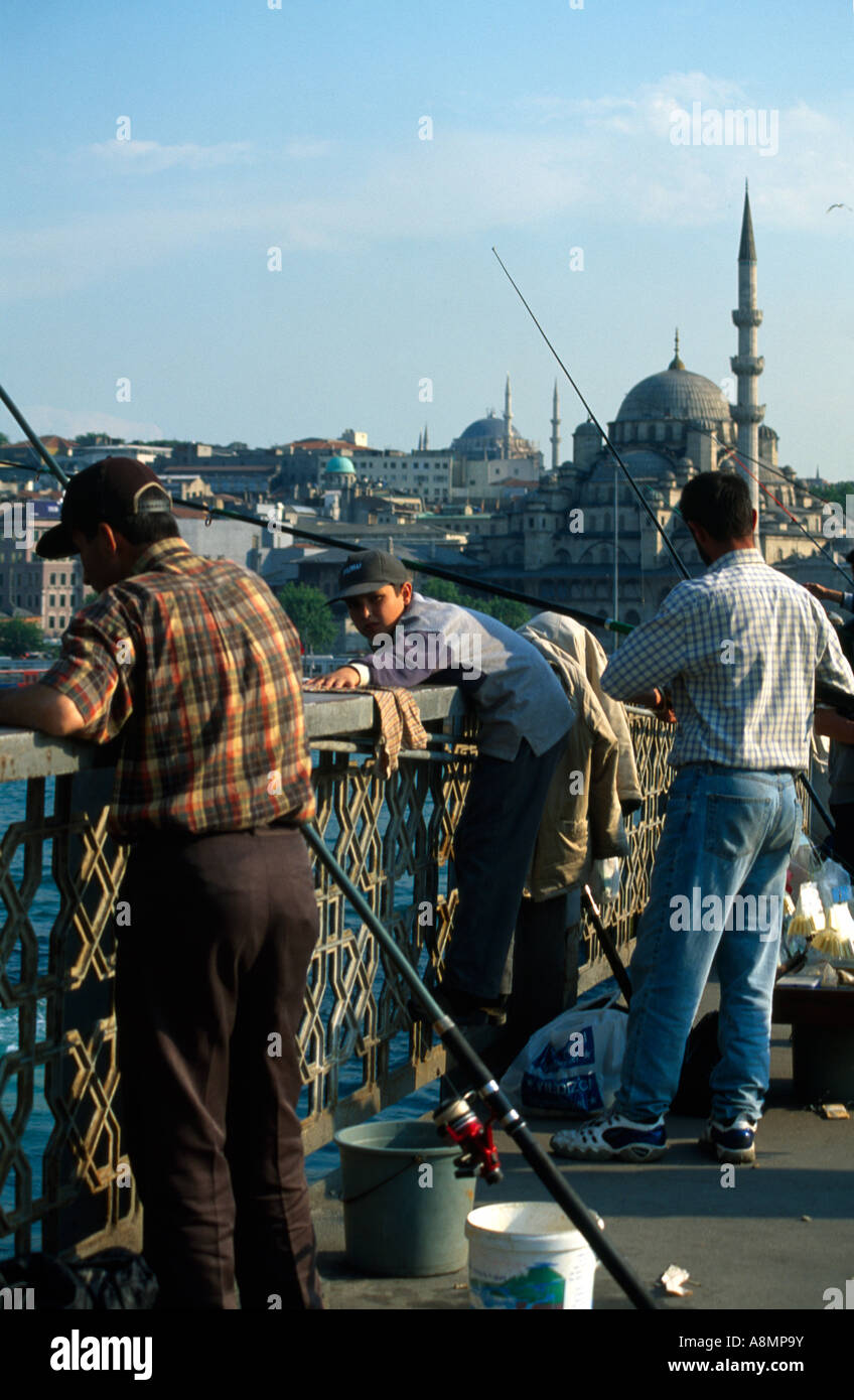 Istanbul Türkei Menschen Angeln von der Galata-Brücke Yeni Camii in der Ferne Stockfoto
