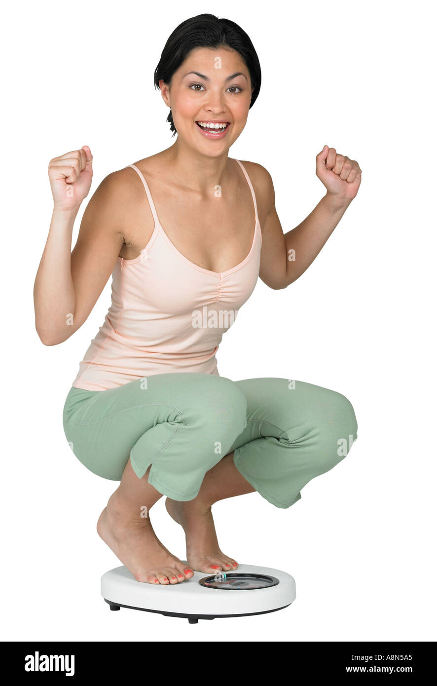 Eine Frau mit einem Gewicht von selbst auf einer Skala Stockfoto