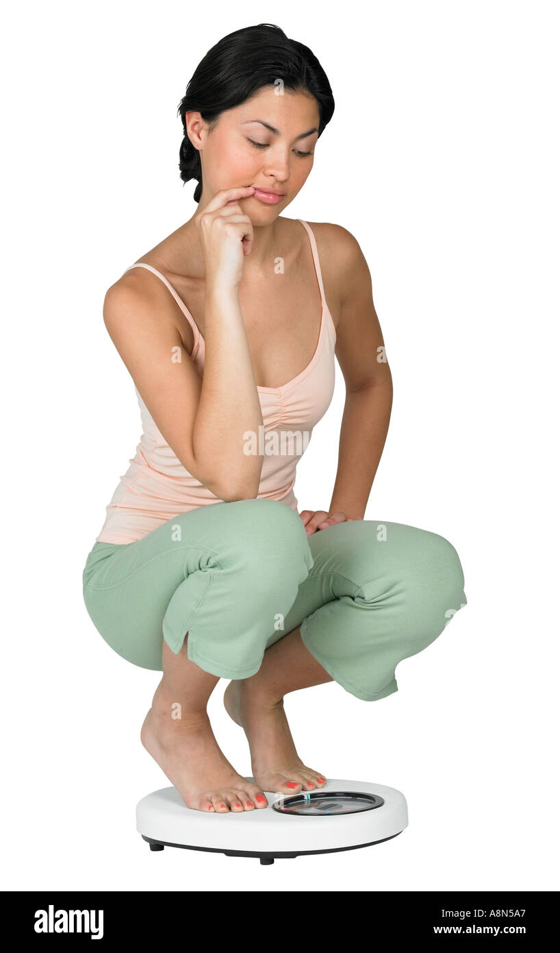 Eine Frau mit einem Gewicht von selbst auf einer Skala Stockfoto