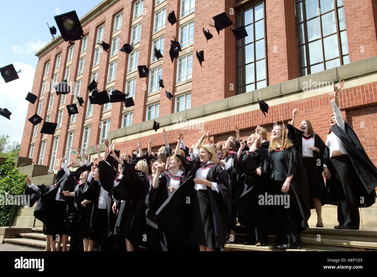 Absolventinnen und Absolventen jubeln für ein Foto nach einer Abschluss-Zeremonie in Birmingham University UK 2004 Stockfoto