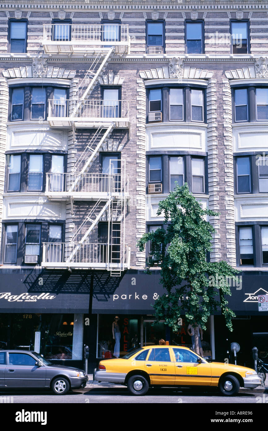 Geschäfte und Feuer entweicht an Gebäuden auf 9th Avenue im Greenwich Village New York ein Auto und ein yellow Cab vor Chelsea Bereich New York USA Stockfoto