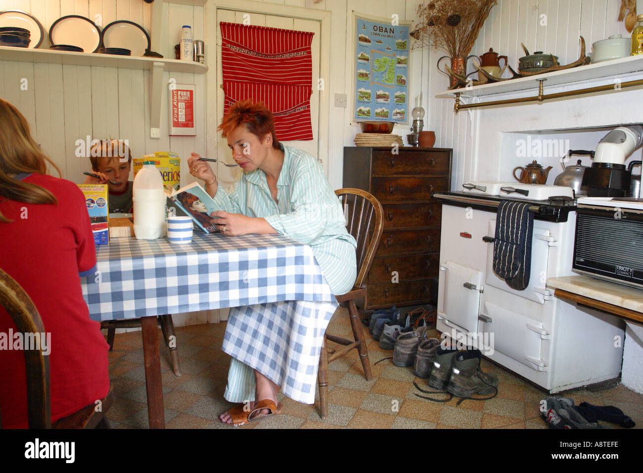 Familie im Urlaub in einem gemieteten Ferienhaus mit Holzverkleidung in den schottischen Highlands zu frühstücken Stockfoto