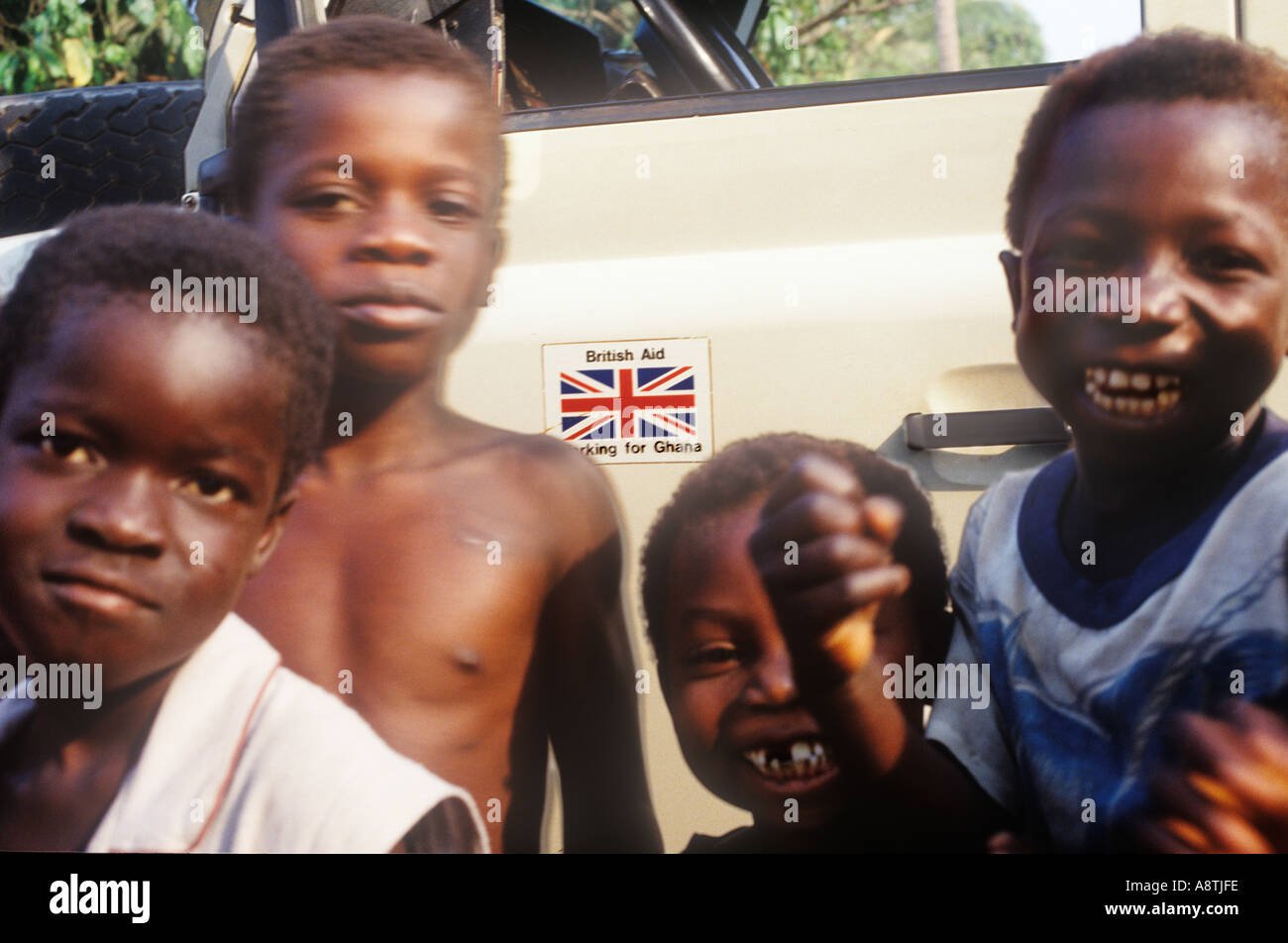 Kinder umgeben British Council Land Rover landwirtschaftliche Berater, das Dorf Tromeso Ghana gebracht hat Stockfoto