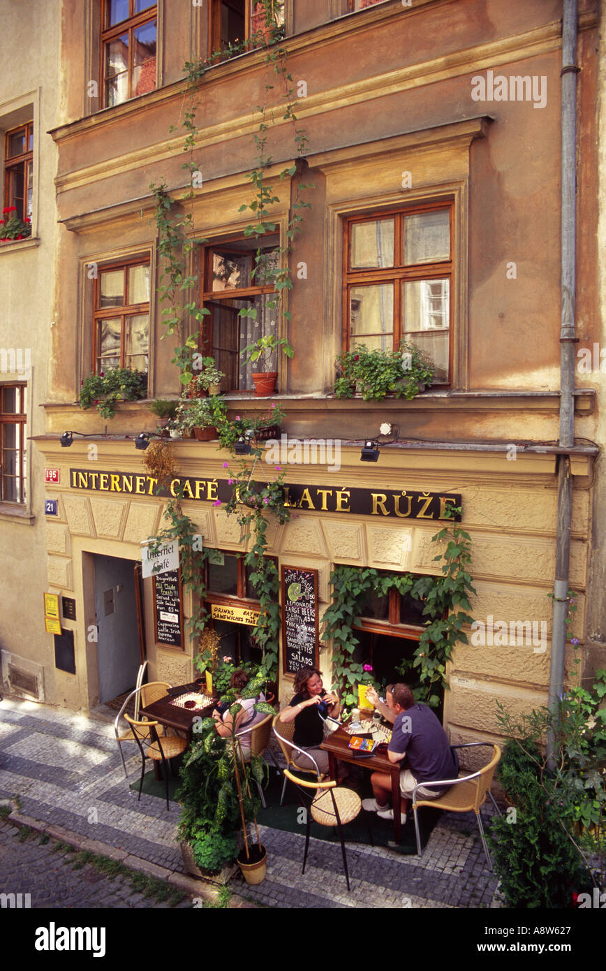 Blick von einer erhöhten Position aus auf Personen, die an Tischen sitzen Vor einem Internetcafe in Prag mit Schleppanlagen Das 3stöckige Gebäude Stockfoto