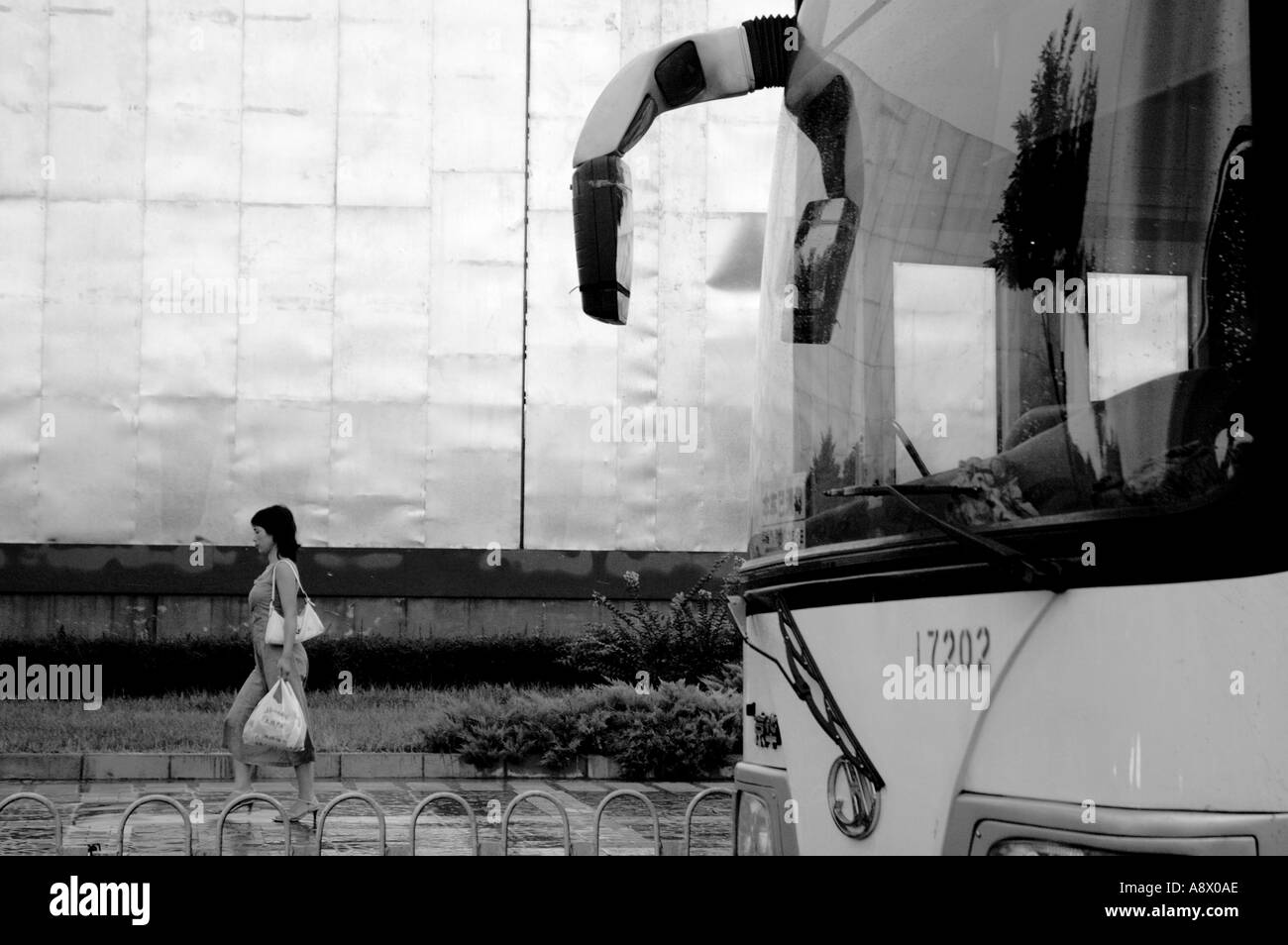 China Beijing Bus Windschutzscheibe und eine Fußgängerzone Frau auf dem Bürgersteig Stockfoto