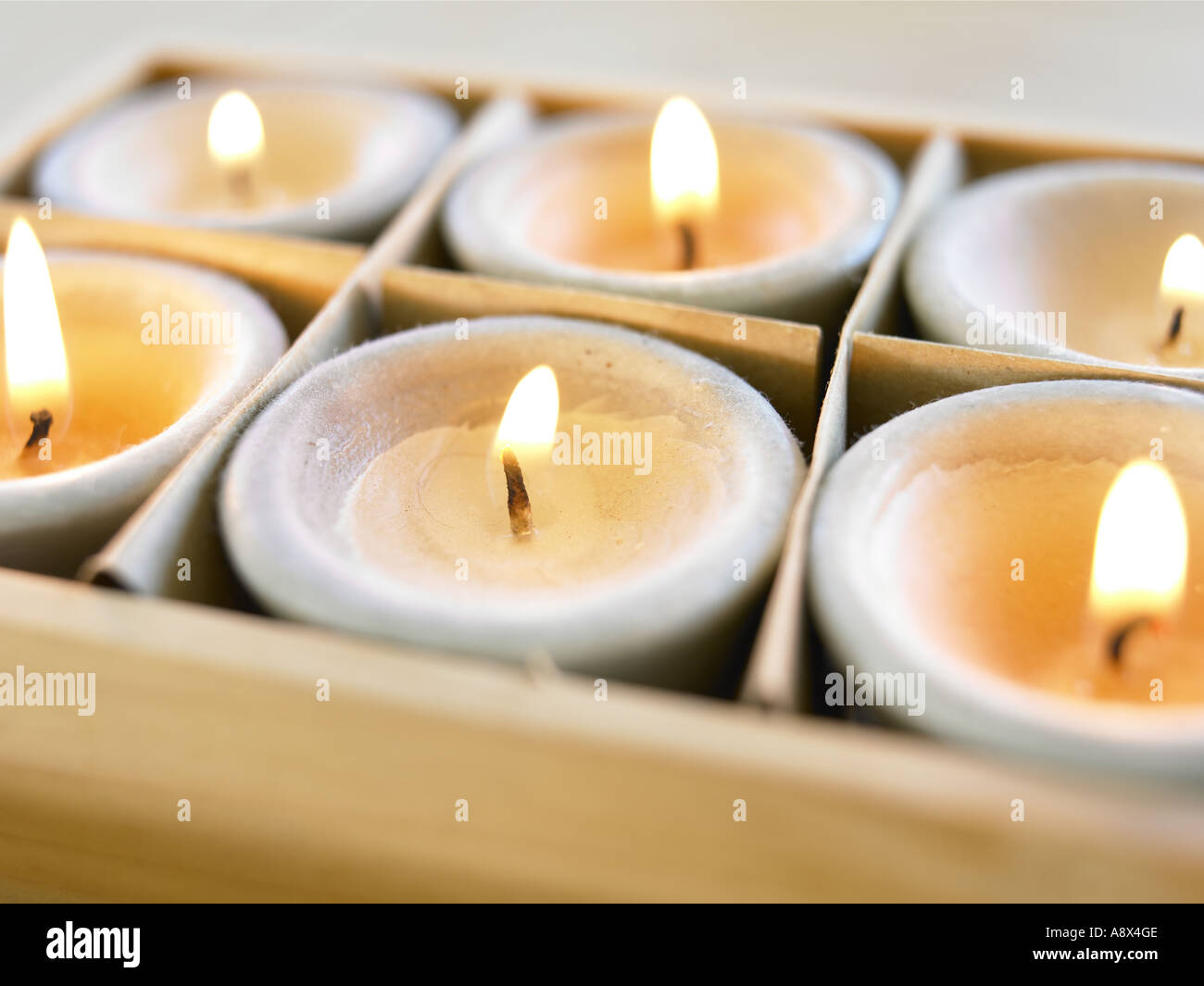 kleine Kerze leuchtet und glüht in Holzkiste Stockfotografie - Alamy
