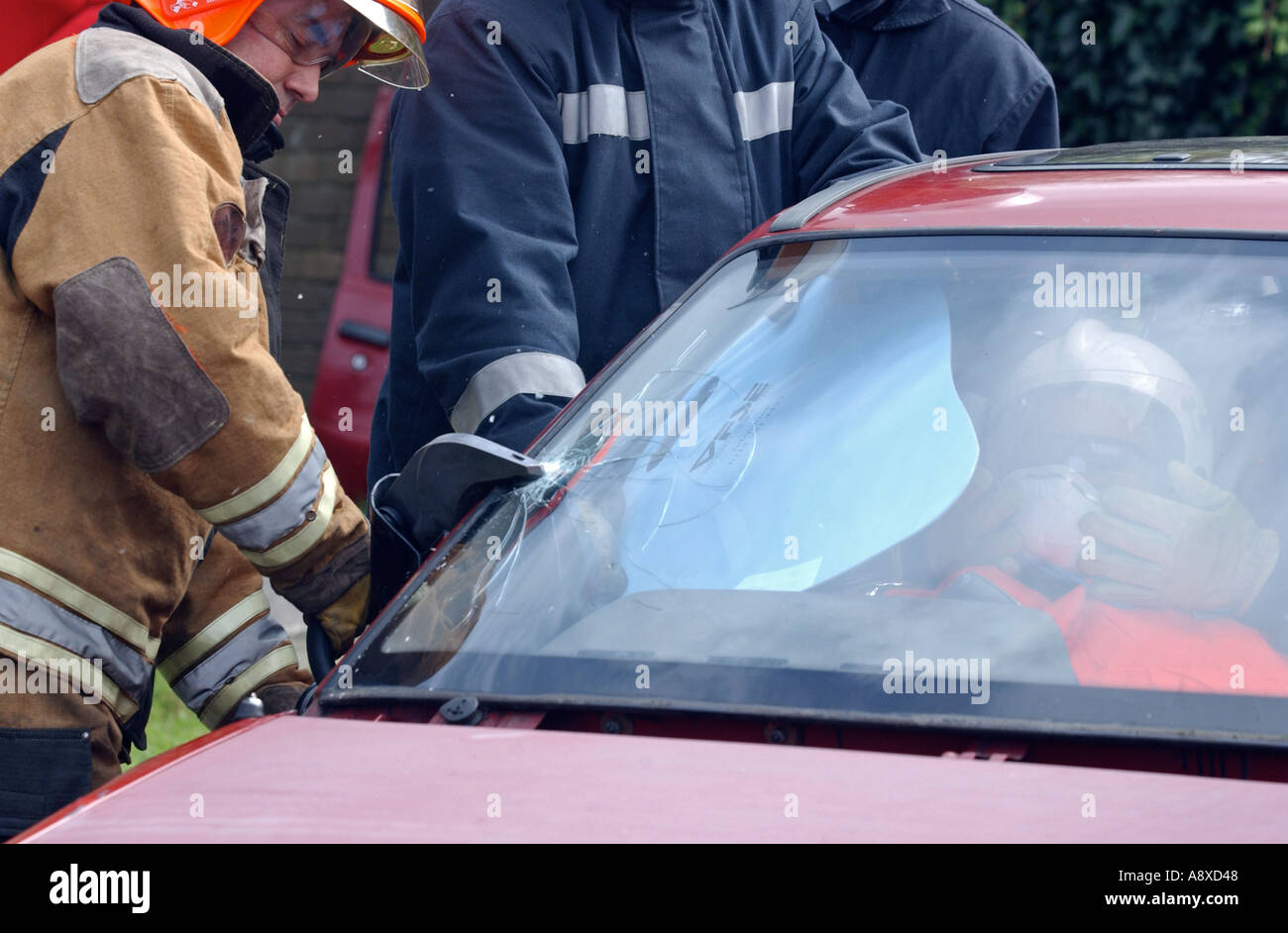 Feuerwehrleute, die aufgeschnitten, dass ein Auto während einer Trainingsübung Stockfoto