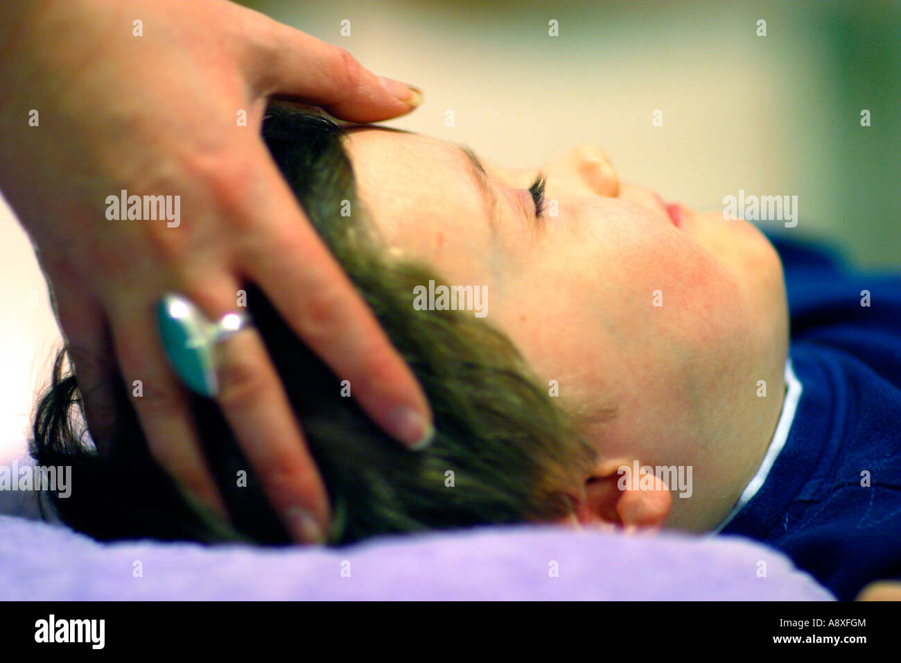 Fünf Jahre alten Jungen vor dem Hopi-Ohr-Kerze-Behandlung entspannen Stockfoto