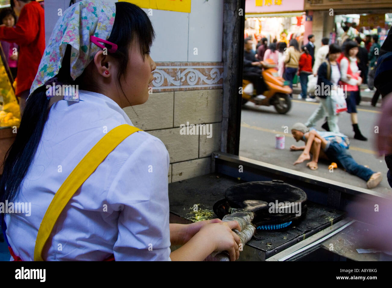 Frau Braten Suppen Obdachloser ziehen sich entlang der äußeren Guangzhou China Stockfoto