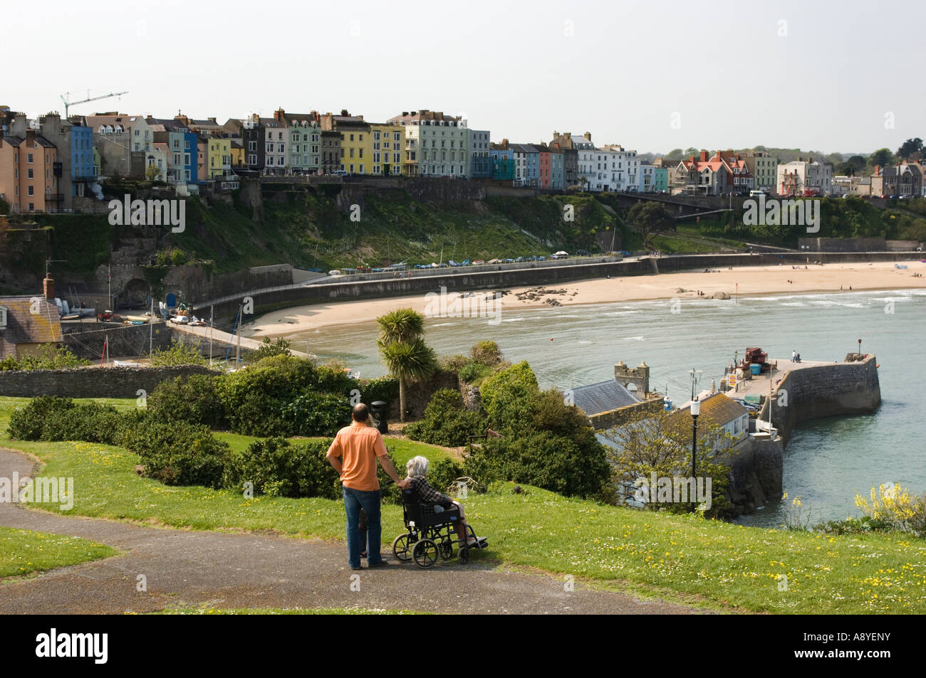 Tenby Pembrokeshire West Wales gesehen von Schloss-Hügel mit Blick auf Nordstrand, Sommernachmittag, Frau im Rollstuhl + Helfer Stockfoto