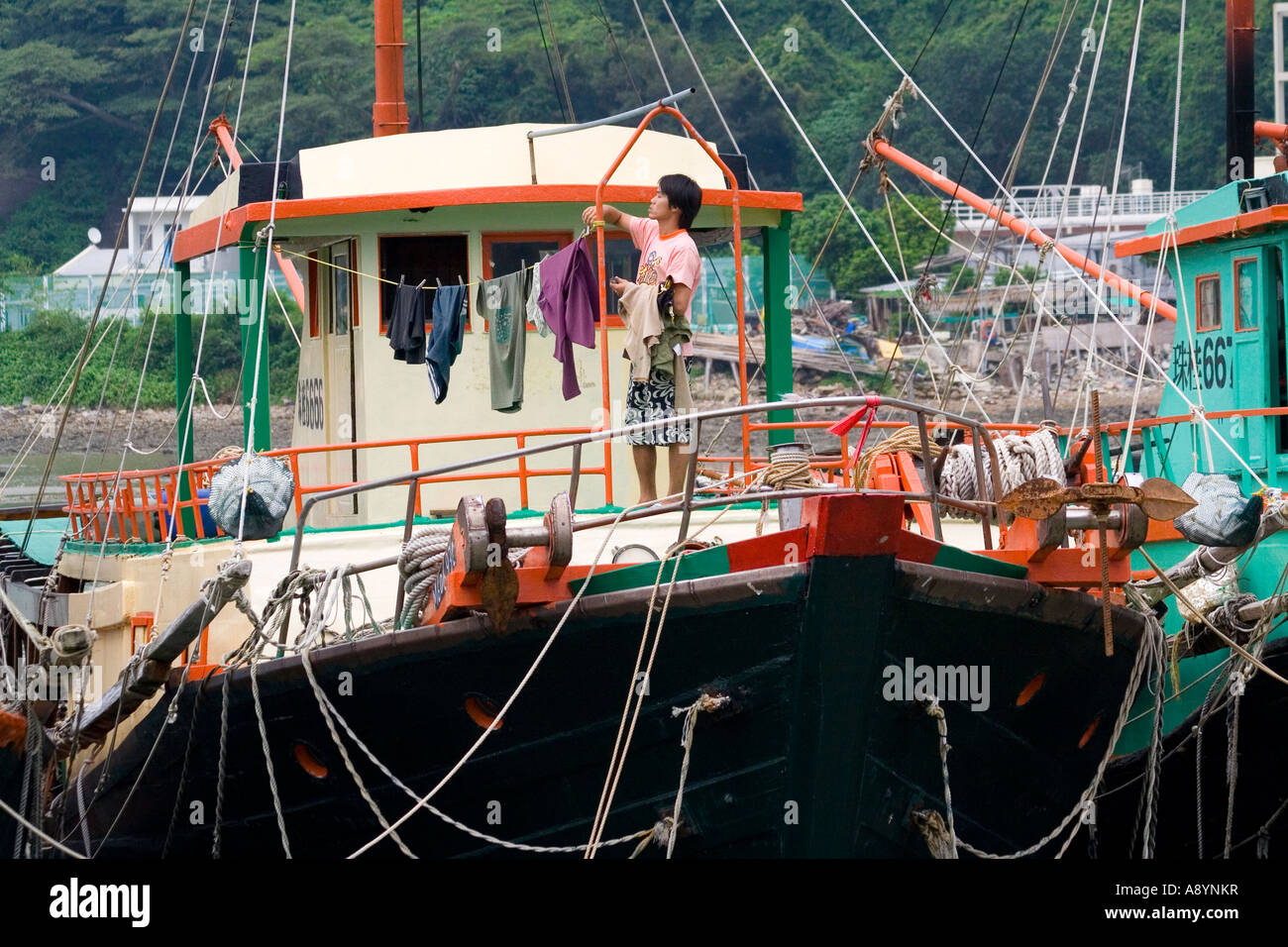 Fischer, Aufhängen von Wäsche auf einem Angeln Boot Tai O alte Fischerei Dorf Lantau Insel Hongkong China Stockfoto