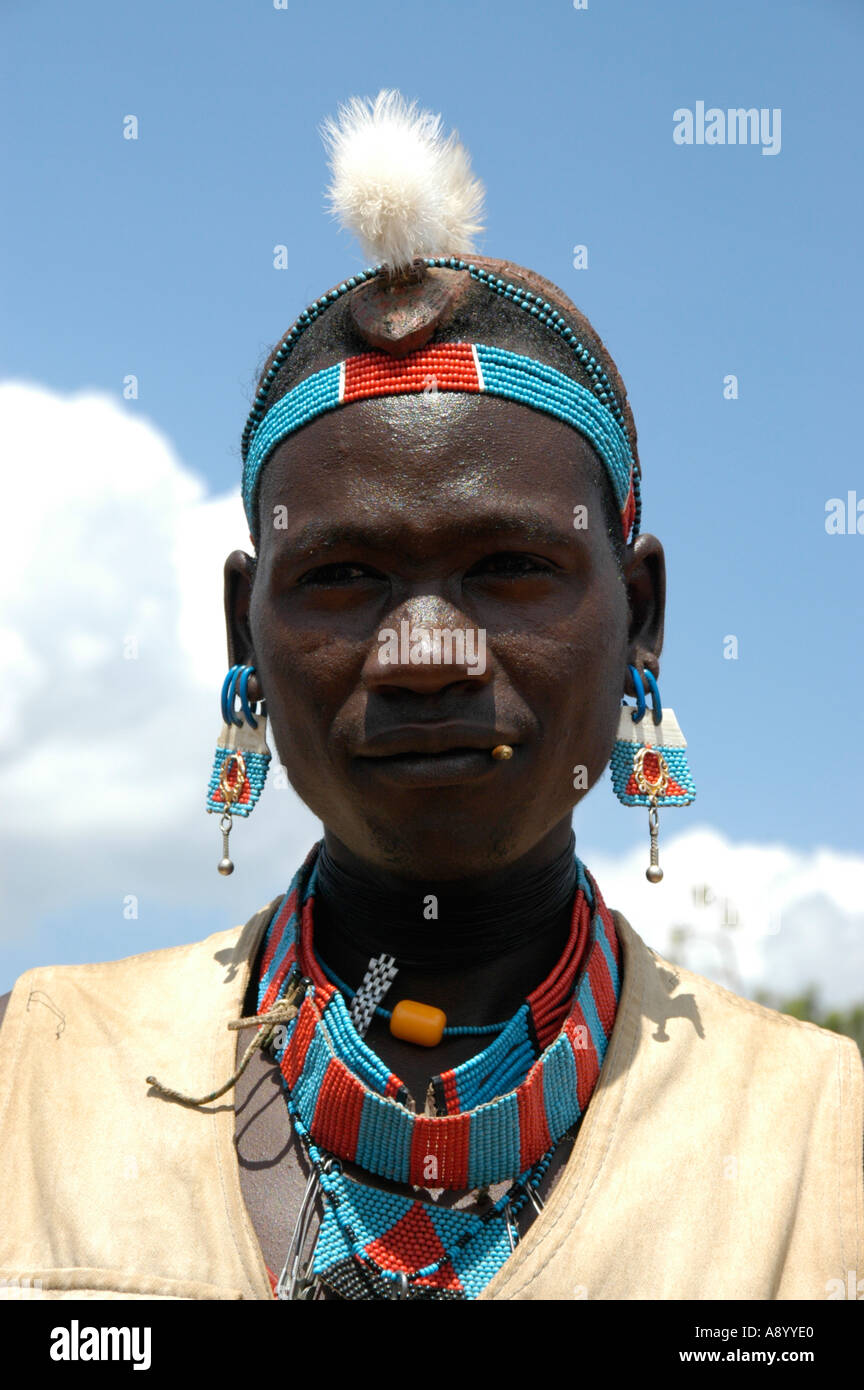 Mann mit bunten Necklesses und Verzierungen und eine Feder in seinem Haarmarkt Keyafer Äthiopiens Stockfoto