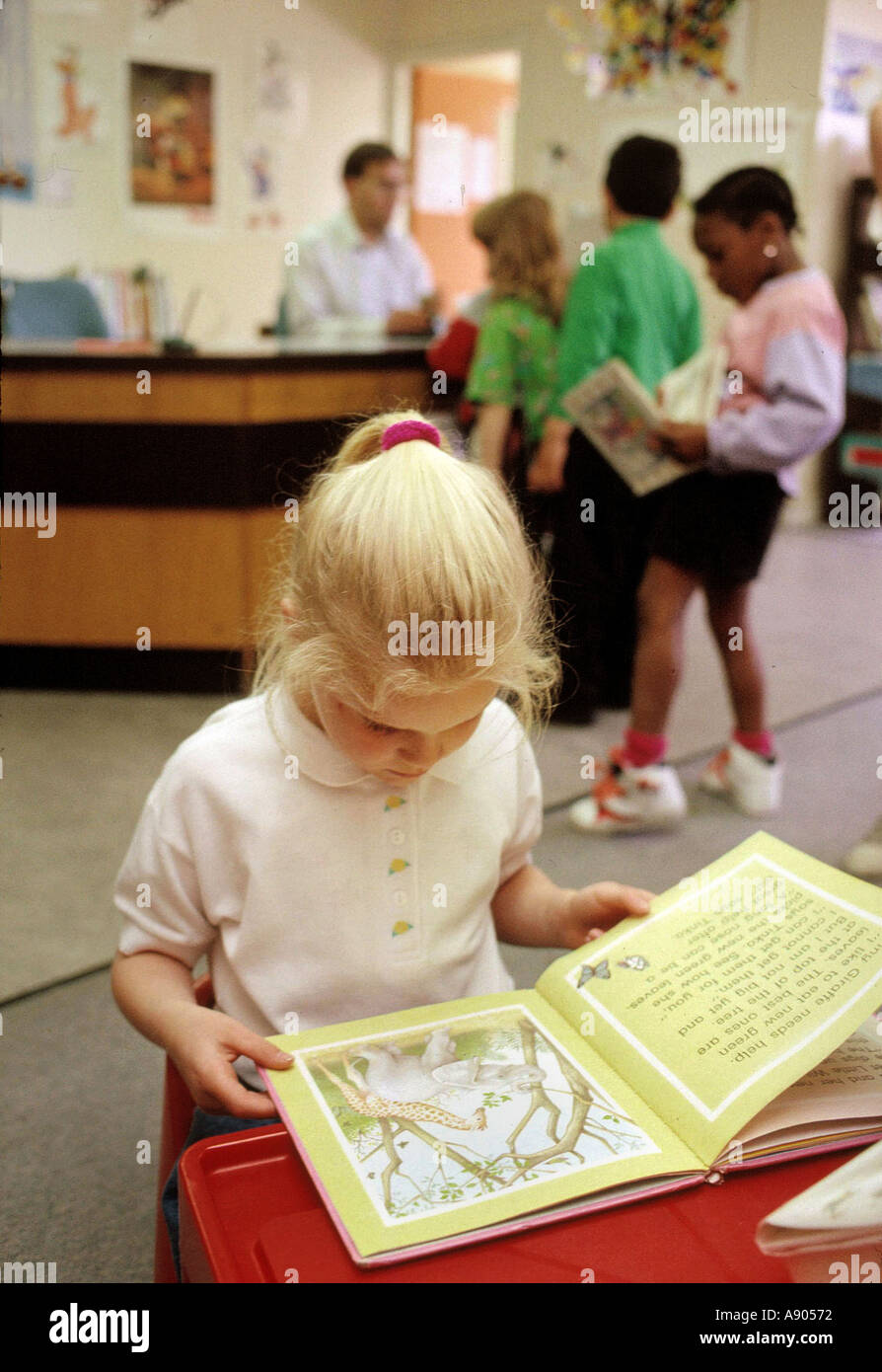Kind in der öffentlichen Bibliothek UK lesen Stockfoto