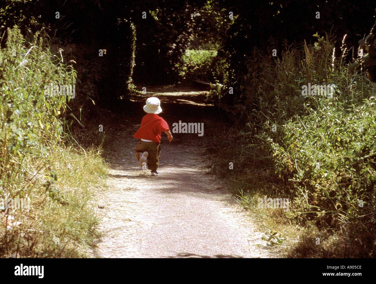 Kleiner Junge läuft ein Feldweg Stockfoto