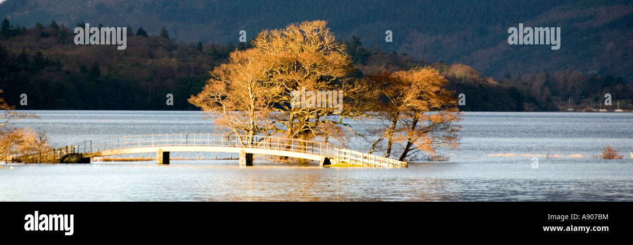Lake District National Park Derwent Water Überschwemmungen nach Starkregen teilweise eintauchen Fußgängerbrücke Sonne fangen Winterbäume Stockfoto