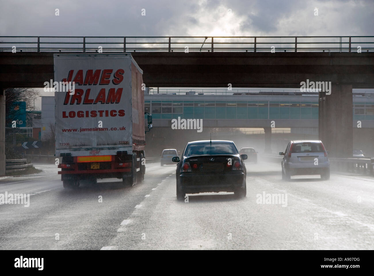 Winter-Autobahn Fahrt in Richtung tiefstehende Sonne nach starkem Regen Dusche schlechte Sicht von Spray von LKW & andere Verkehrsteilnehmer hochgeworfen Stockfoto