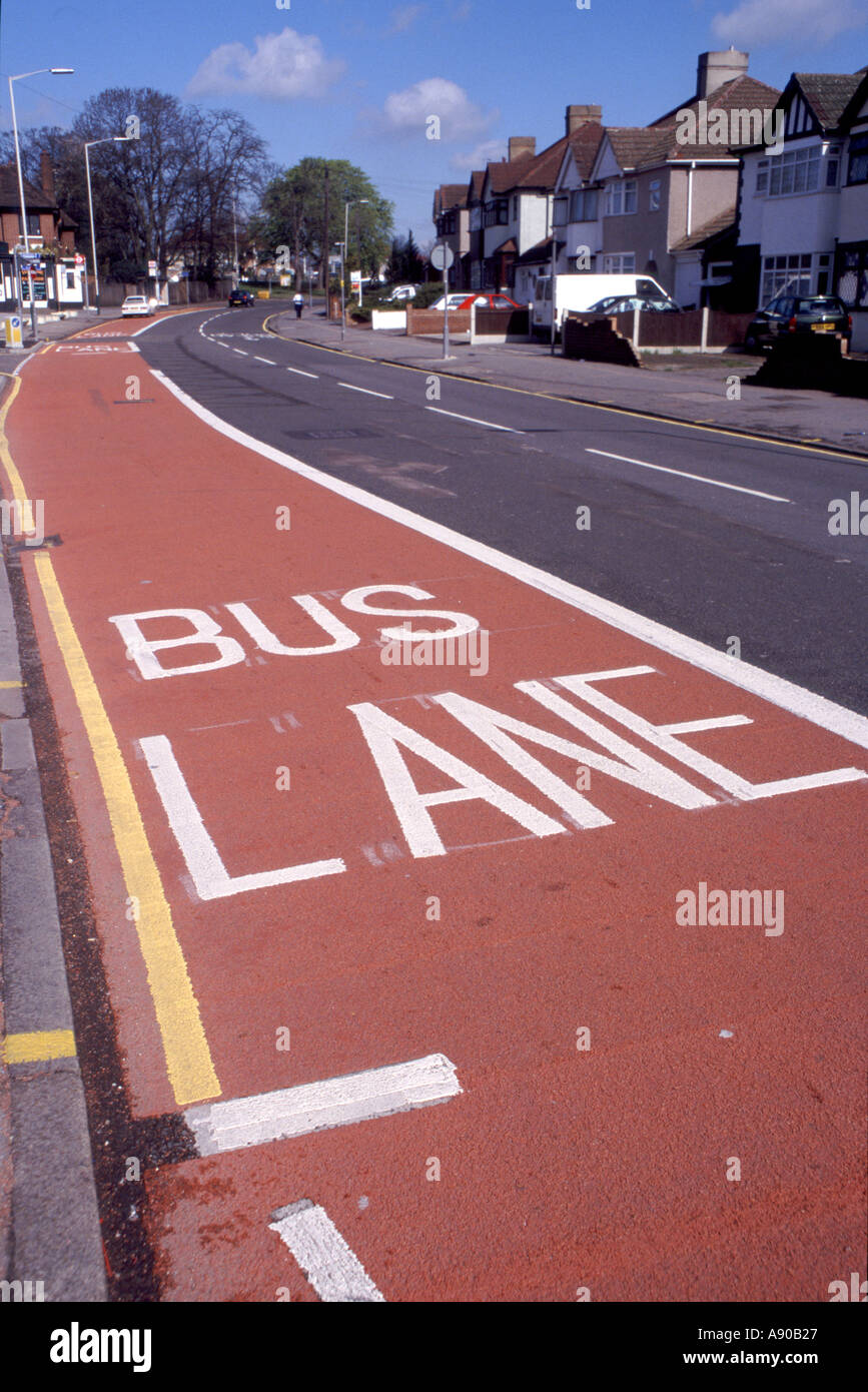 Weiße Buchstaben auf rotem Asphalt für Bus Lane getrennten Verkehr mit gelben Parkplatz Einschränkung Linien Romford Havering London England UK (wurde in Essex) Stockfoto