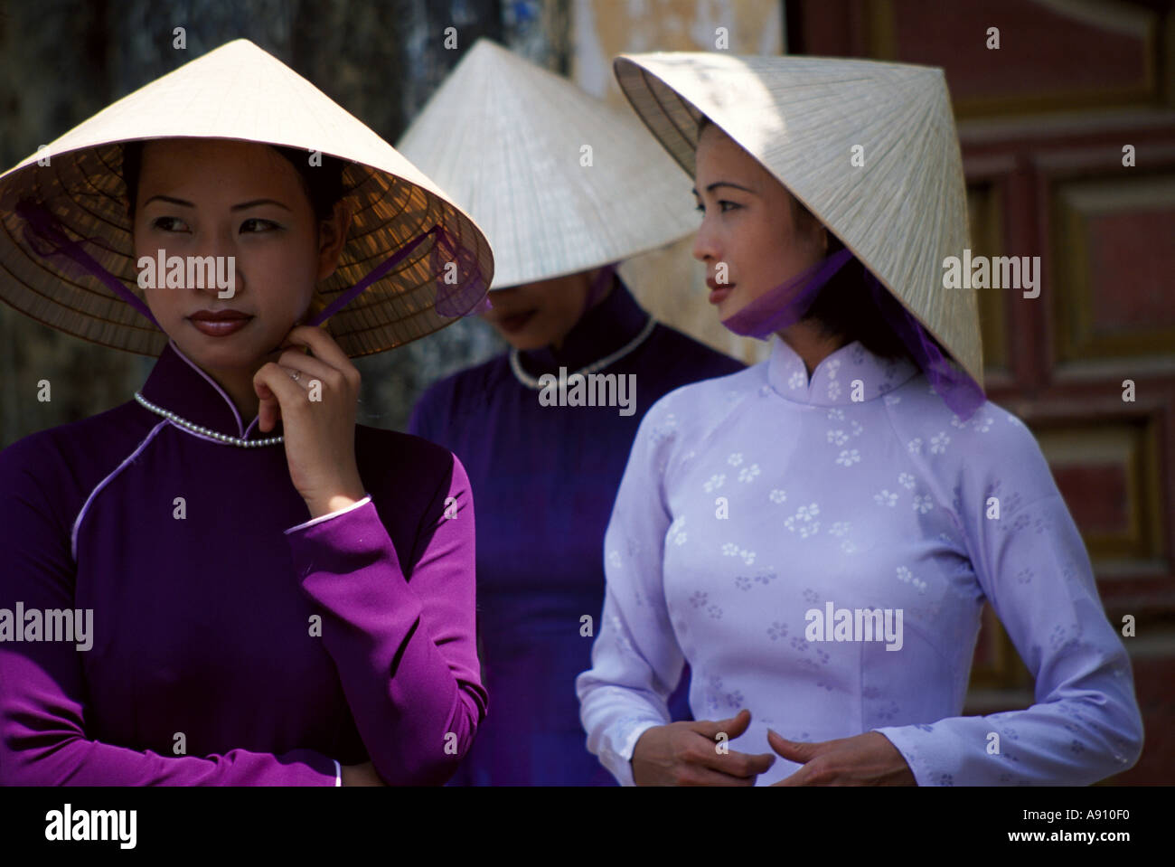 Hübsche Mädchen tragen traditionelle Kostüme und die ikonischen konischen Hüte In Vietnam Stockfoto Hübsche Mädchen tragen traditionelle Kostüme und die ikonischen konischen Hüte In Vietnam Stockfoto