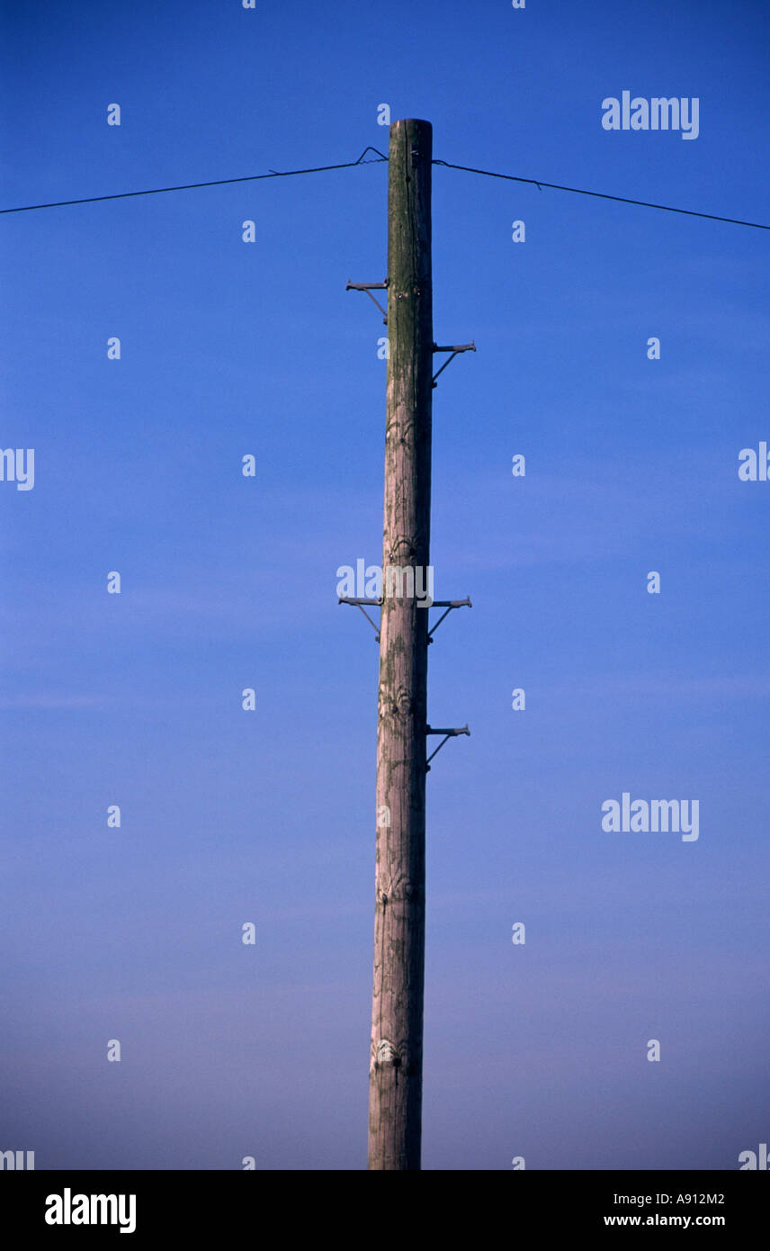 Telegrafenmast und Draht vor blauem Himmelshintergrund Stockfoto