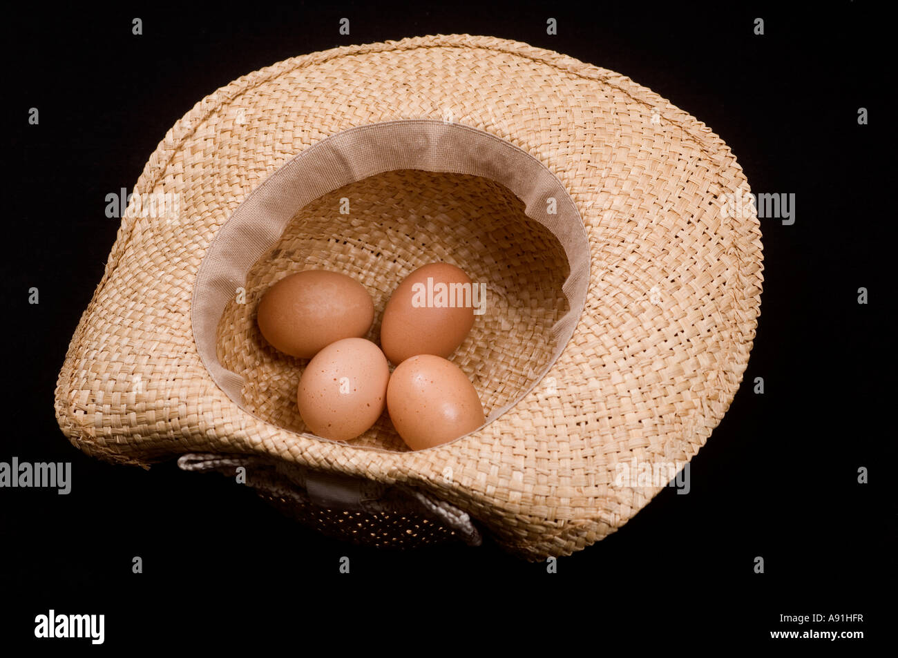 4 Eiern in einen Strohhut Stockfoto