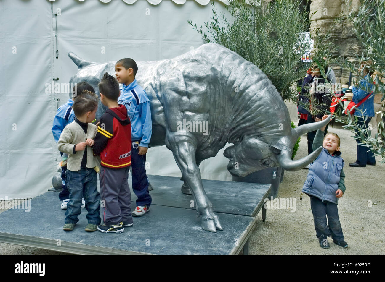 Arles, Frankreich, Feria Stierkampfskulpturfestival Straßenszene, gemischte Gruppe französischer Kinder, spielen mit öffentlichen Statuen, Freunde auf der Straße, s Stockfoto