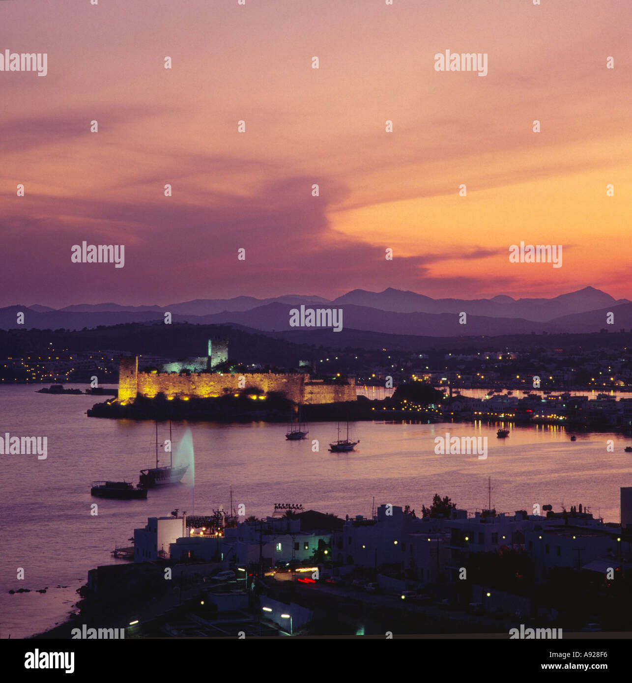 Orange sunset Himmel über der Stadt am Meer, die Bucht und Hafen und die Ritter von St. John schloss beleuchtet in Bodrum, Türkei Stockfoto