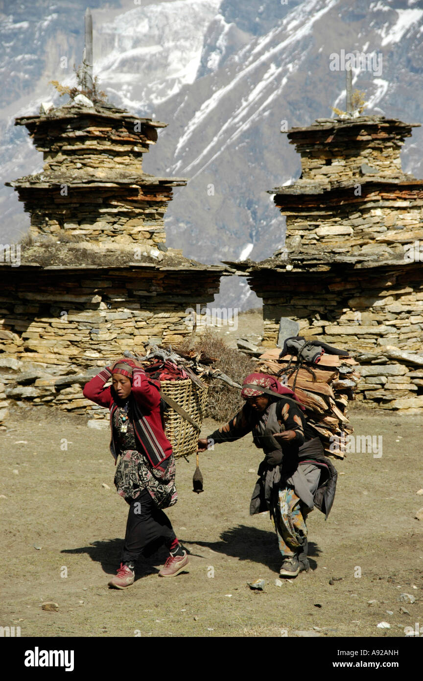 Zwei gepackte Tibeter spazieren buddhistischen Tempel Choerten mit schneebedeckten Hänge des Berges Kang Guru im Hintergrund Nar Stockfoto