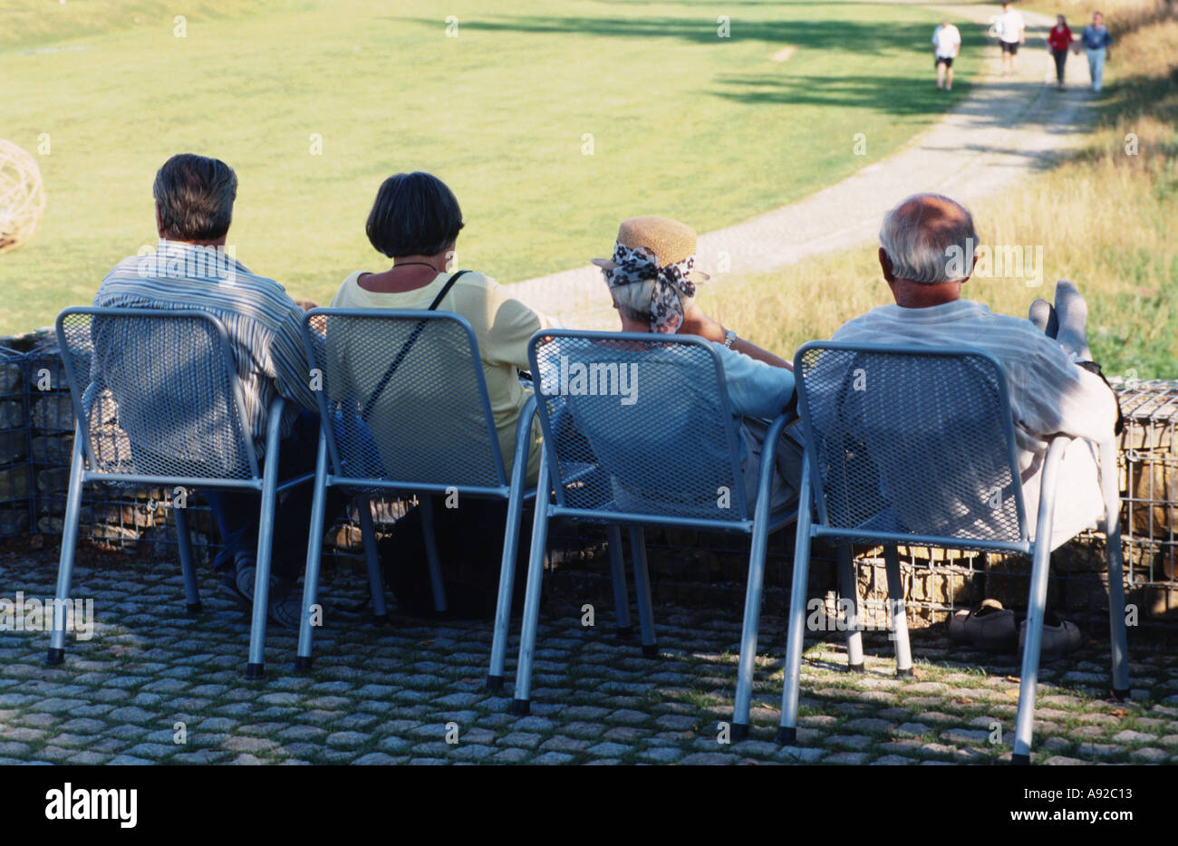 4 Personen sitzen im Stuhl Stühle Sonntagnachmittag Alter 60 Rentner Ruhestand Alter Senioren Urlaub Stockfoto