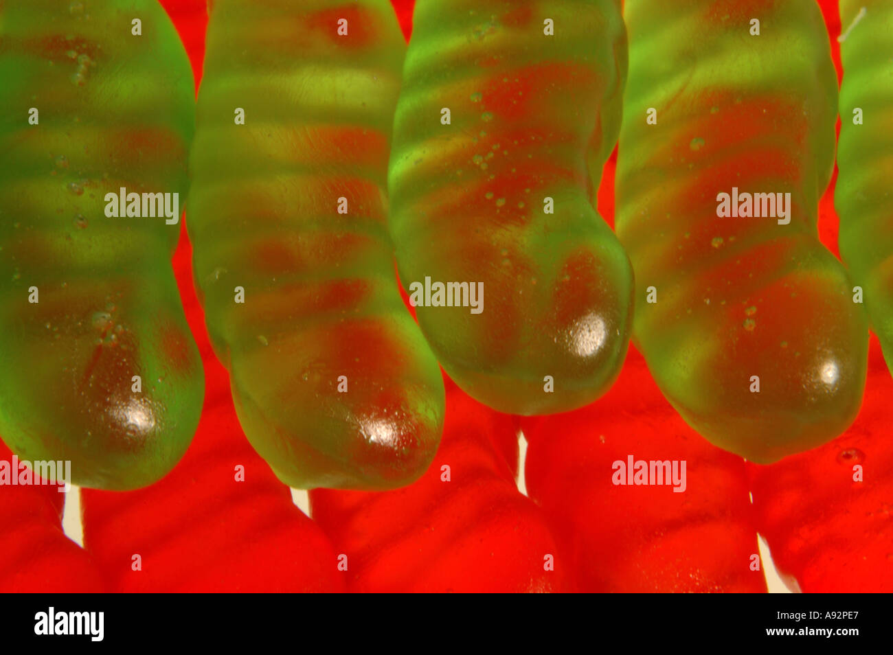 Nahaufnahme von roten und grünen Gelee Wurm Süßigkeiten von unten beleuchtet Stockfoto