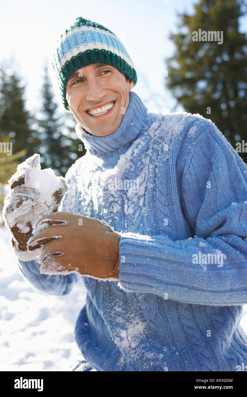 Mann trägt Winter Kleidung Holding Schneeball, portrait Stockfoto