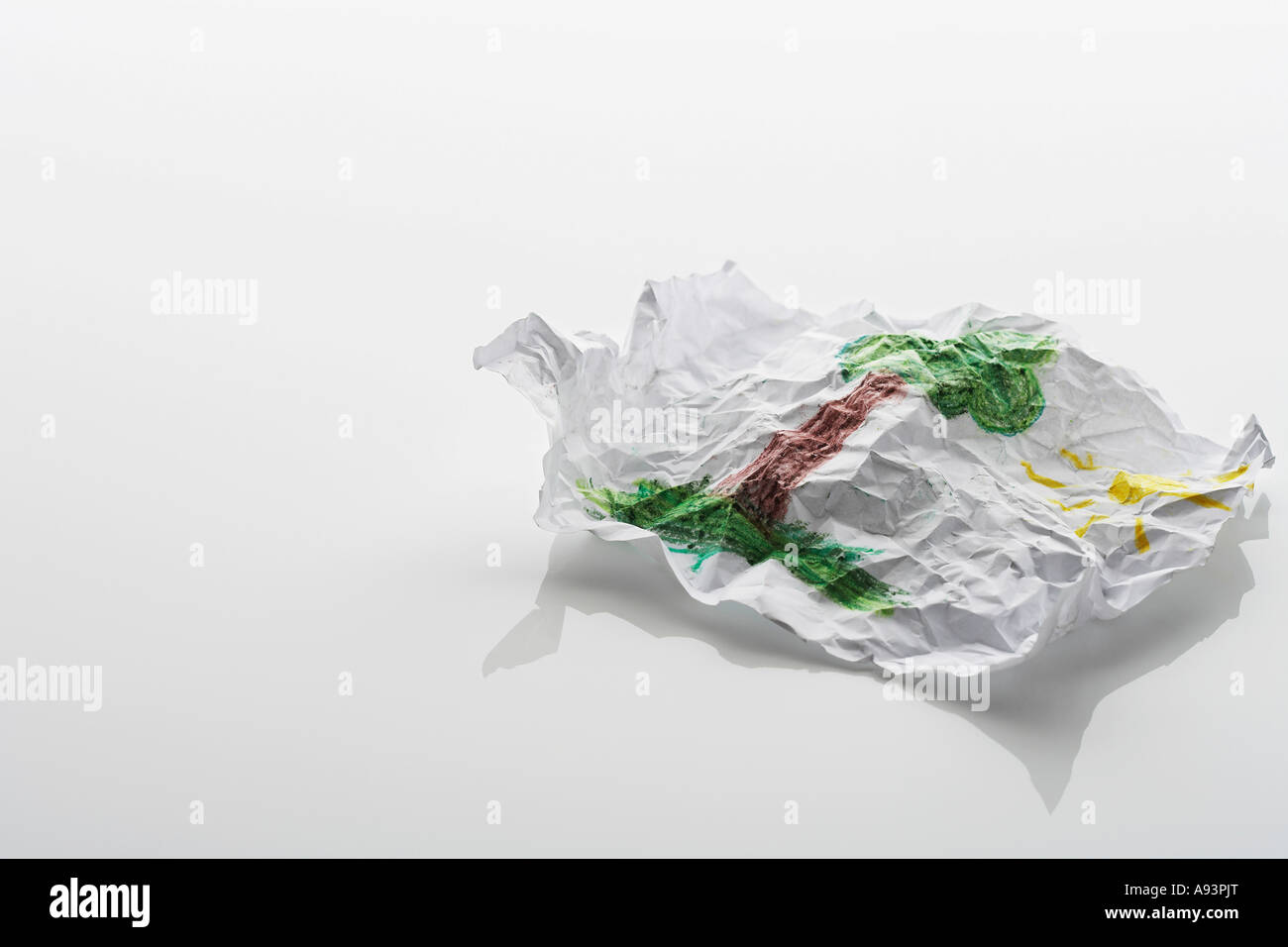 Zerknittertes Blatt Papier mit Zeichnung von Baum und Sonne Stockfoto