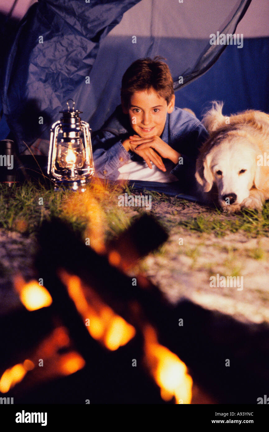 Junge mit seinem Hund vor einem Lagerfeuer Stockfoto