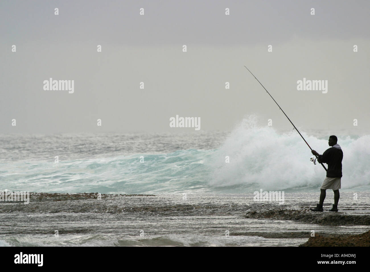 Ein Mann steht am Strand Meer Angeln Kosibay Black Rock Maputaland Kwazulu Natal in Südafrika Stockfoto