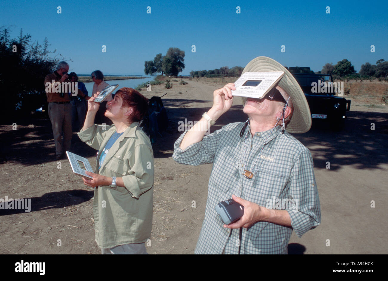 Zwei Touristen beobachten durch abgeschirmte Geräte Sambesi Sambia 2001 totalen Sonnenfinsternis Stockfoto