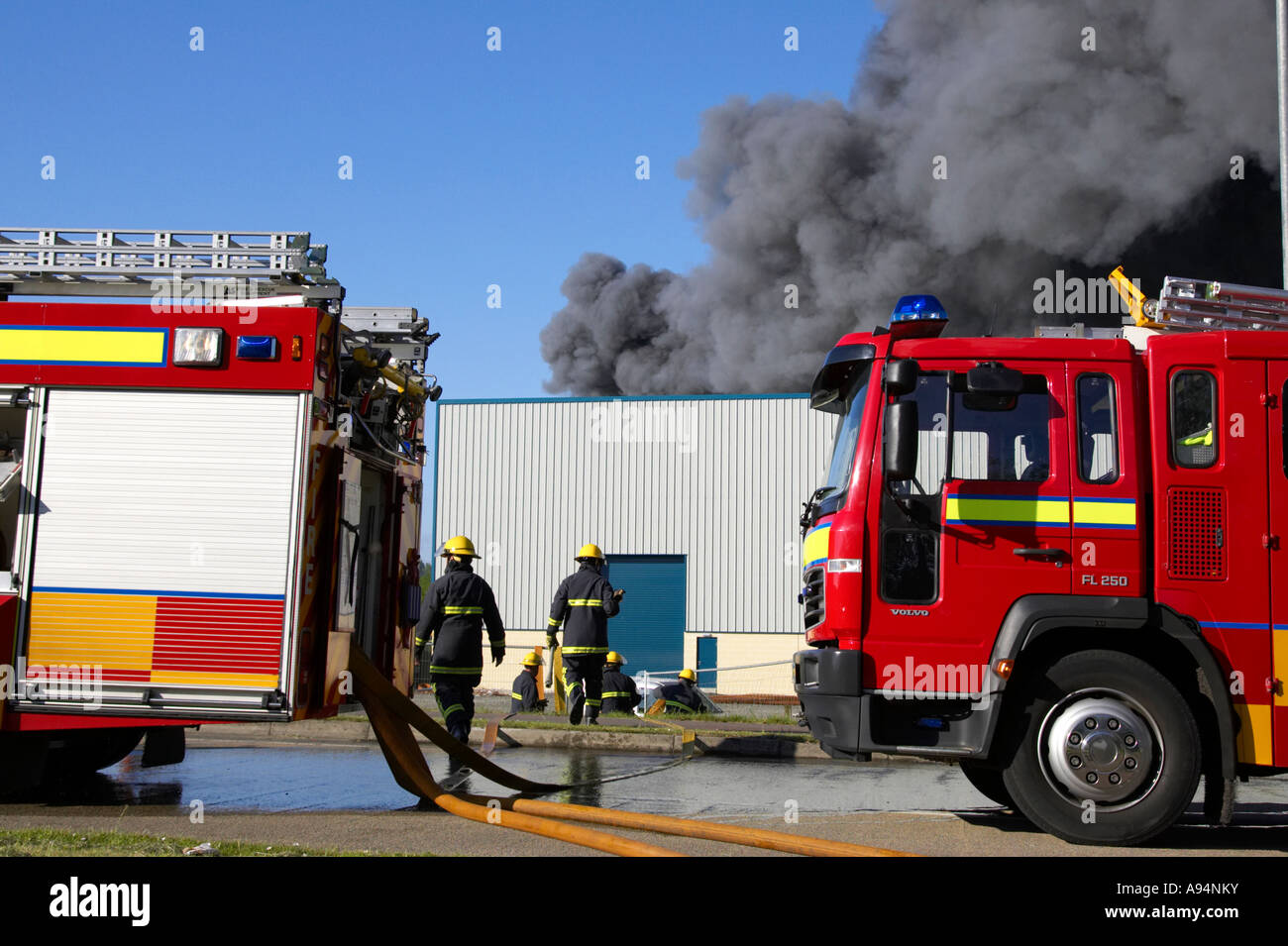 Feuerwehrfahrzeuge mit Schläuchen verbunden unter Rauchsäule am Feuer bei medizinischen Lager coleraine Stockfoto