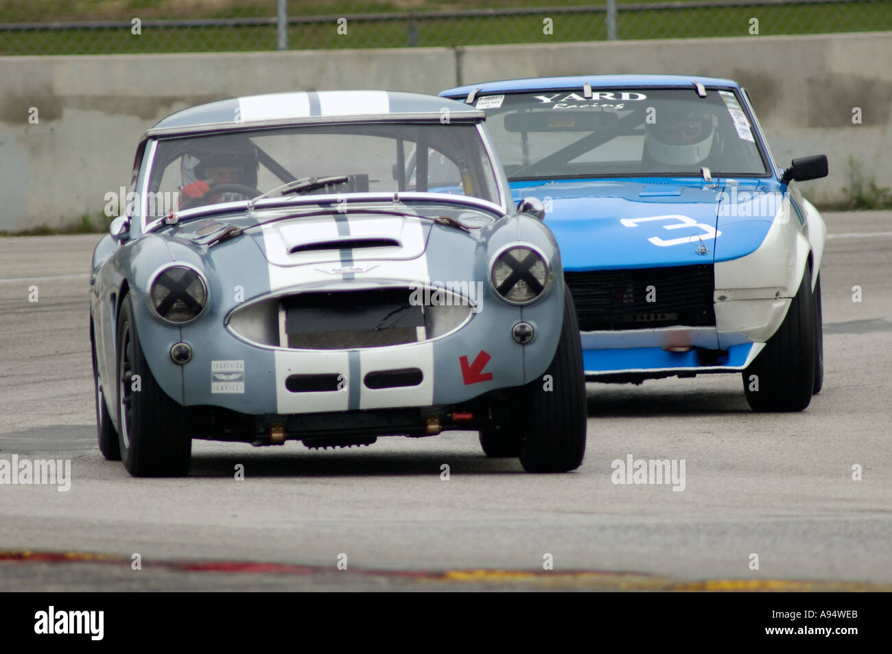 Bob Dillon Rennen seine 1957 Austin Healey 100-6 von Richard Blaha in seinem 1970 Datsun 240Z in Vintage GT Challenge 2005 gefolgt Stockfoto