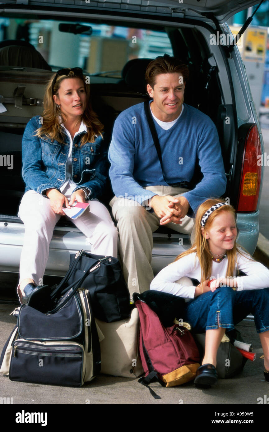Eltern mit ihrer Tochter sitzen in einem offenen Kofferraum Stockfoto
