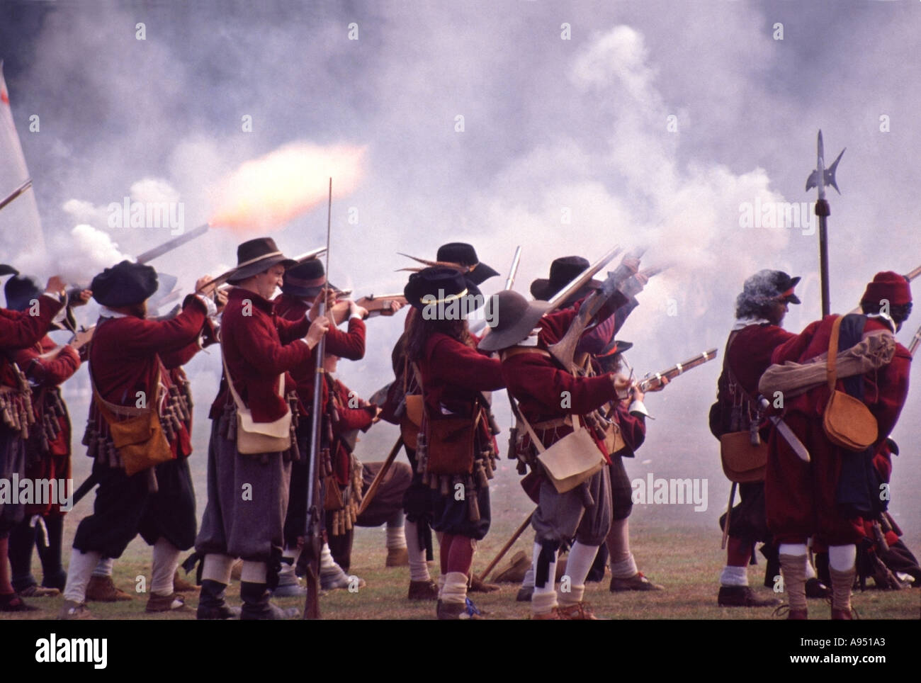 Nachstellung des englischen Bürgerkriegs durch Gruppen wie die English Civil war Society & Sealed Knot Soldiers, die eine Muskettenpistole in einem Kostüm aus Kampfflamme und Rauchzeit abfeuern Stockfoto