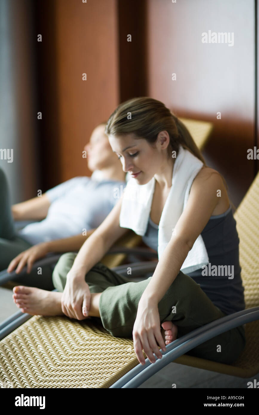 Junge Frauen Entspannung in Lounge-Sessel, einer Sitzung indischen Stil, lächelnd Stockfoto