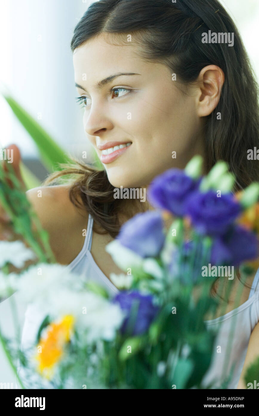 Junge Frau, Blumen im Vordergrund, Porträt Stockfoto