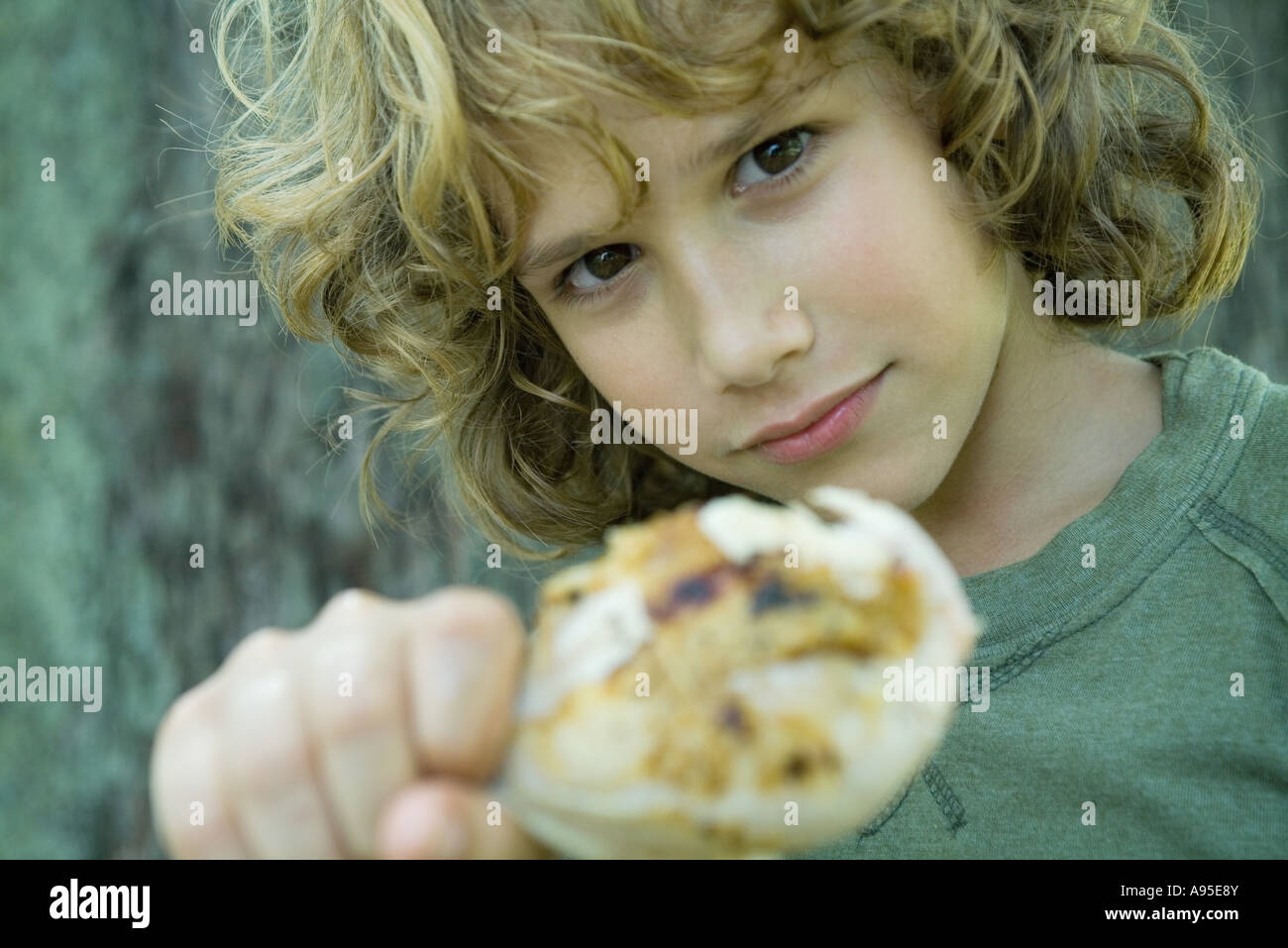 Junge hält gegrillte Hähnchenschenkel Stockfoto