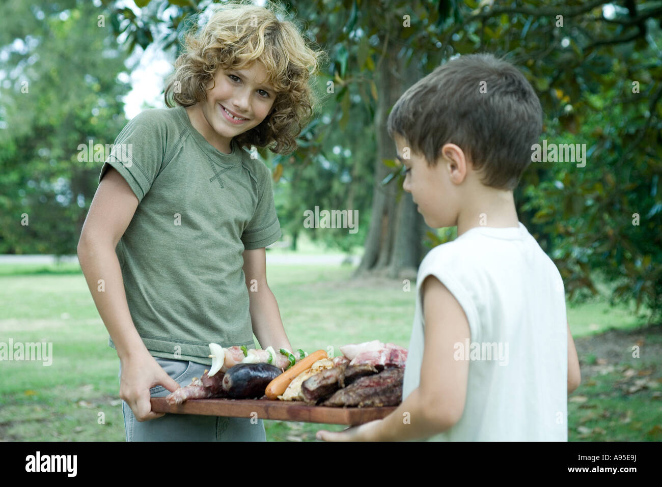 Zwei jungen mit Tablett mit gegrilltem Fleisch Stockfoto